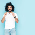 Homem elegante e sorridente posando em estúdio